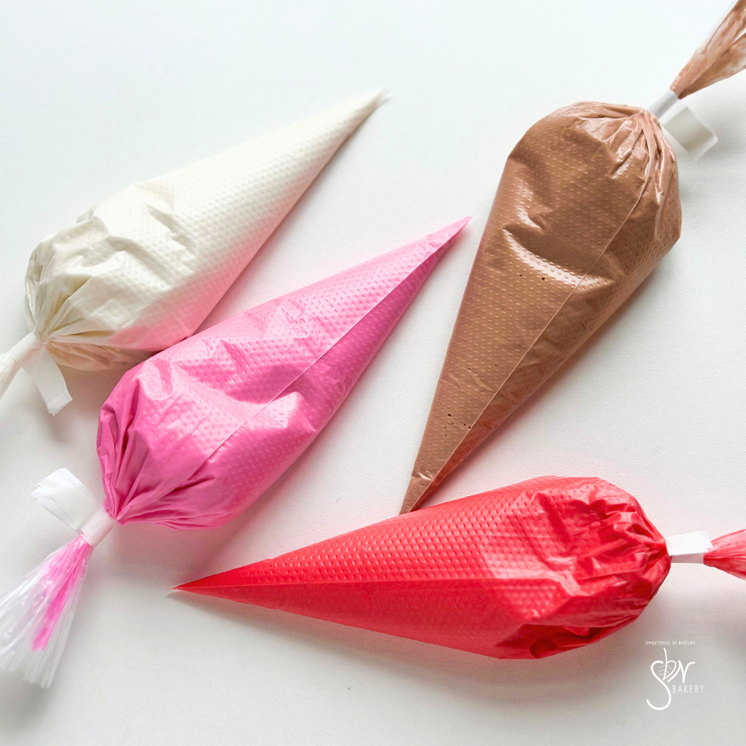 bags of royal icing in white, pink, red and brown